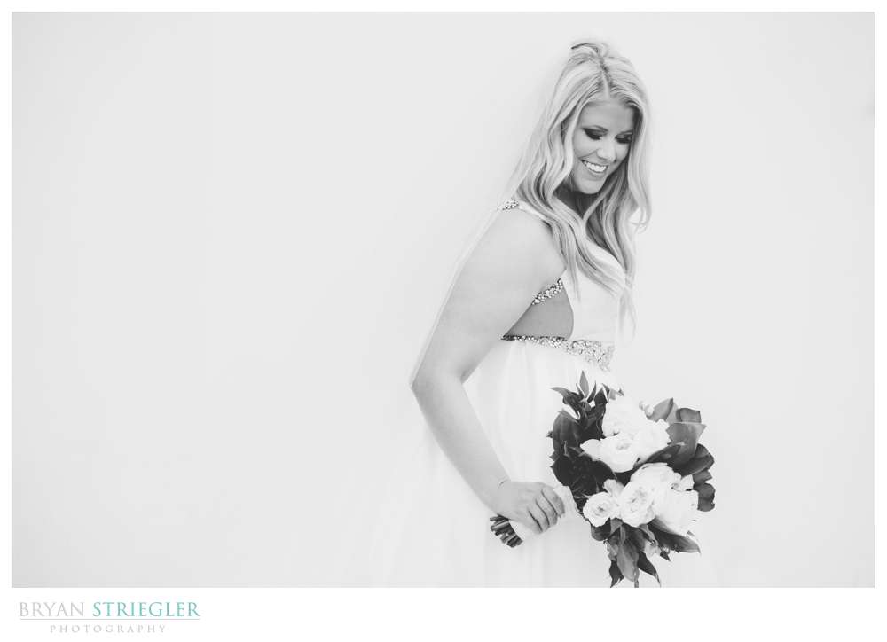 black and white bridal portrait in front of white wall